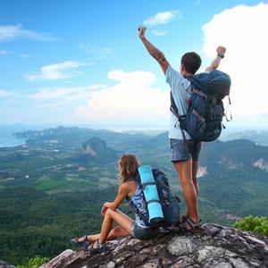 Woman and Man climbing to top of mountain Uncle Bud's blog post pain releif